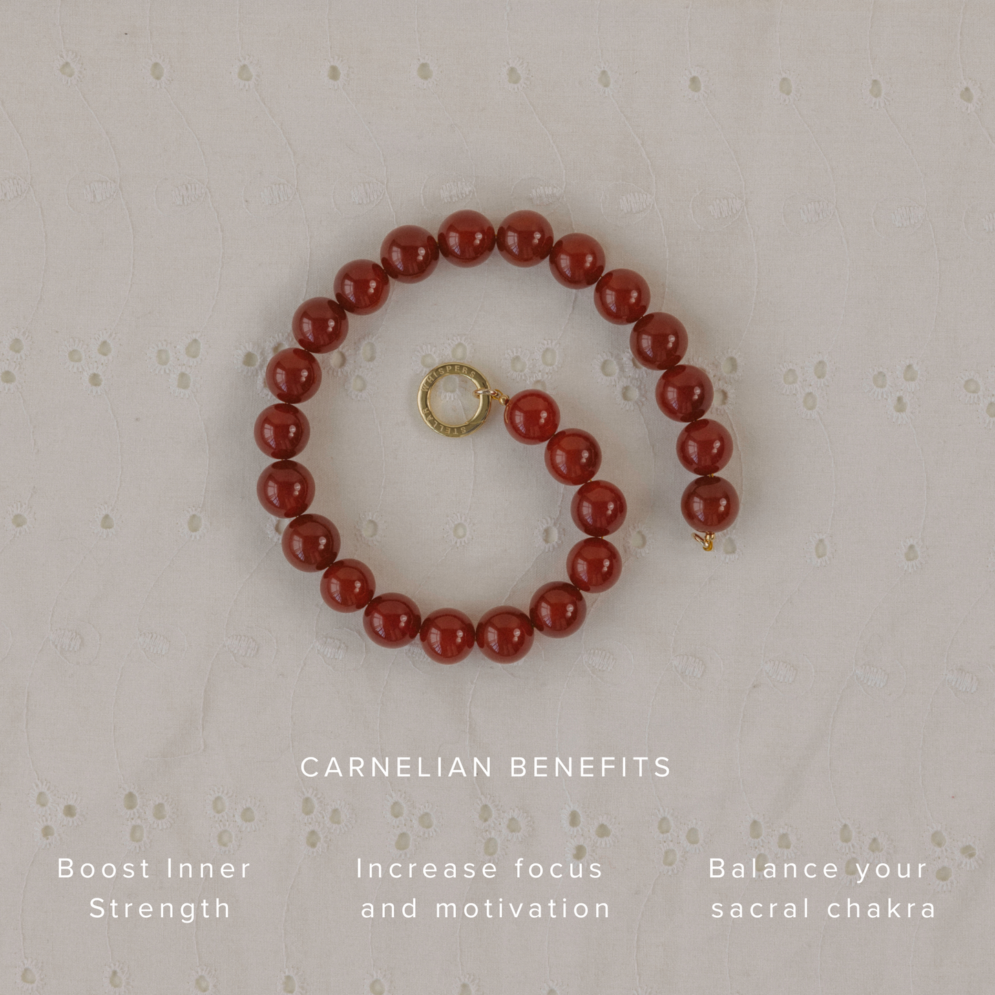 Carnelian crystal necklace coiled on embroidered fabric, highlighting benefits: inner strength, focus, and sacral chakra balance.
